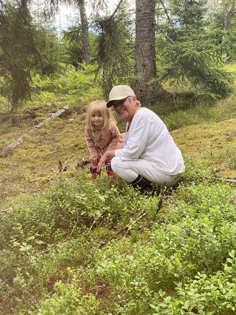 Oma pflückt Beeren mit Emma